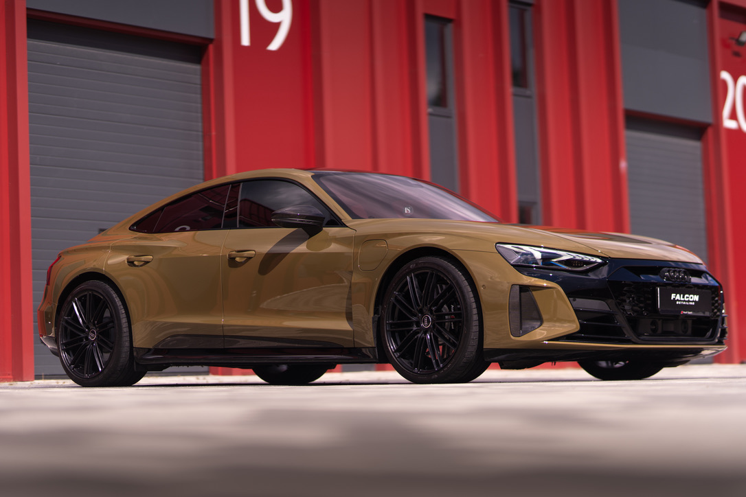Золотистий Audi e-tron GT біля студії Falcon, вигляд спереду збоку