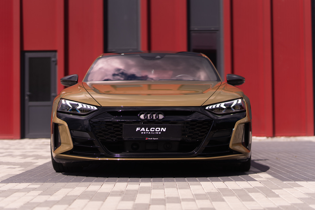 Золотистий Audi e-tron GT біля студії Falcon, вигляд спереду