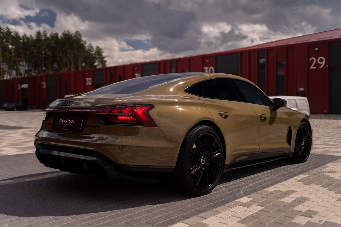Золотистий Audi e-tron GT біля студії Falcon, вигляд ззаду збоку